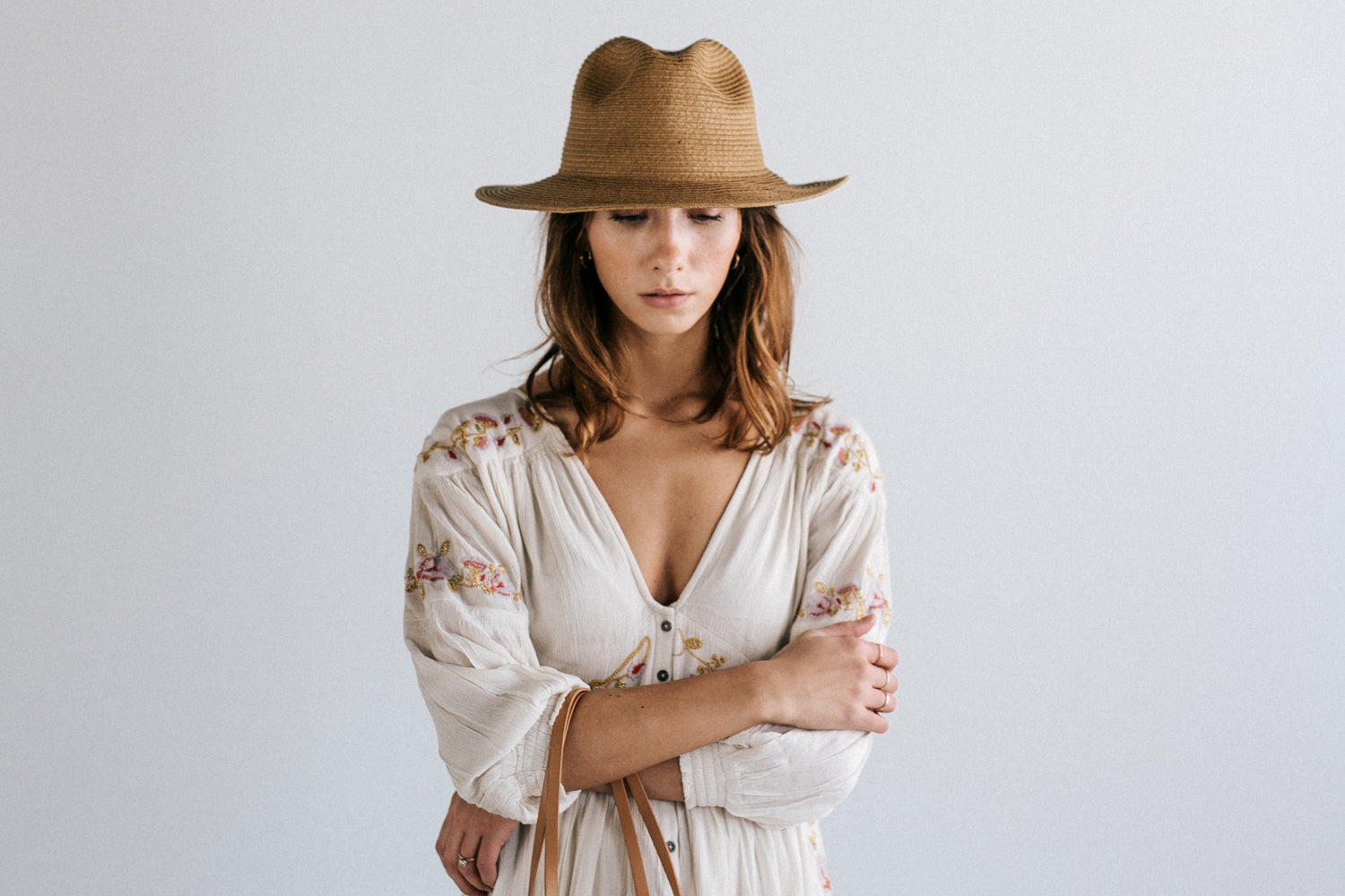 woman wearing straw hat folding arms